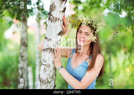 Hübsche junge Frau mit einem Blumenkranz auf dem Kopf Stockfoto