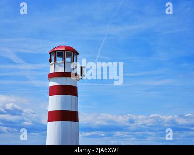 Rot-weißer Leuchtturm in Podersdorf am See, Österreich, vor blauem Sommerhimmel am Neusiedler See. Stockfoto