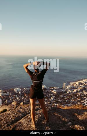 Rückansicht einer Frau, die am Rand steht. Weibliche Entspannung nach der Wanderung genießen die Aussicht. Stockfoto