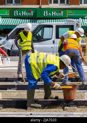 Paris, Frankreich, Leute der Gruppe, Männer, ausländische Bauarbeiter, die Beton auf Straßenbahngleisen anwenden, Arbeiter frankreich, Einwanderer Stockfoto