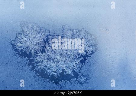 Schneemuster auf dem Glas von Frost. Muster von Schneeflocken auf dem Fenster Stockfoto