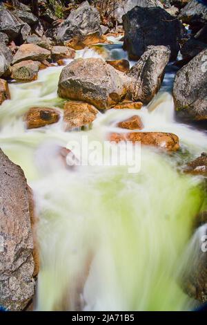 Detail von blauem Wasser, das durch den Fluss über Felsen fließt Stockfoto