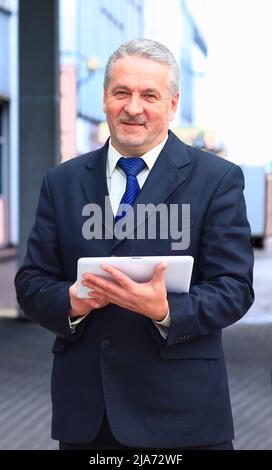 gut aussehend Geschäftsmann mit Tablet-PC im modernen Büro Stockfoto
