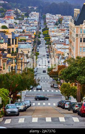 Endlose steile Straße in San Francisco, gesäumt von bunten Häusern Stockfoto