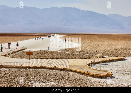 Badwater Basin Promenade im Death Valley mit Touristen, die Formationen erkunden Stockfoto