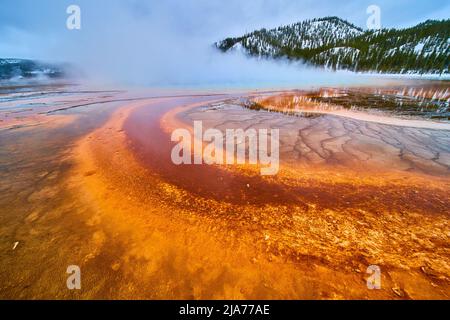 Grand Prismatic Spring mit erstaunlichen roten und orangen Wasserschichten in der Nähe von blauen Tiefen, die mit Dampf bedeckt sind Stockfoto