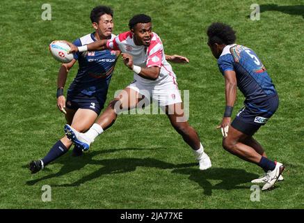 Die englische API Bavadra (Mitte) kämpft mit den japanischen Kameli Raravou Latianara Soejima (rechts) und Yuki Ishii (links) während des 15. Spiels der HSBC World Rugby Sevens Series im Twickenham Stadium, London, um den Ball. Bilddatum: Samstag, 28. Mai 2022. Stockfoto