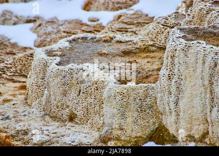 Detaillierte Schichten mit Schneeflecken um Terrassen bei Yellowstone Mammoth Hot Springs Stockfoto