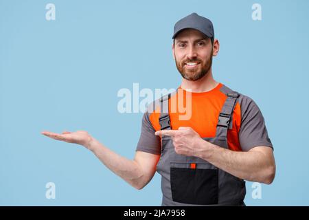 Positive Entbindung Mann steht auf blauem Hintergrund zeigt seinen Finger zur Seite an leerem Ort Stockfoto