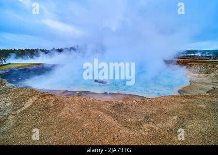 Schlafender Geysir und Krater im Yellowstone, bedeckt mit Schwefeldampf Stockfoto