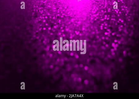 Verschwommener, glänzender Oberflächenfleck im Hintergrund mit neon-violett-rosa hellem abstraktem Fleck-Design. Stockfoto