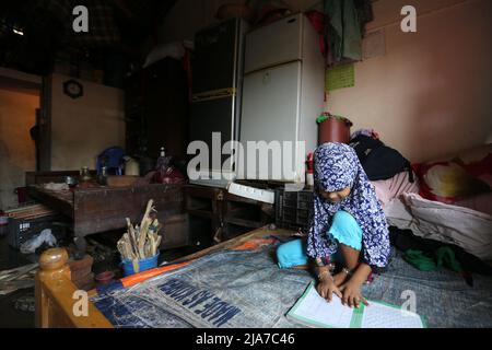 24. Mai 2022, Sylhet, Bangladesh: Ein Kind bereitet seine Lektion über dem Bett vor, während das Haus unter Wasser steht. Das Sturzflutwasser dringt in die Häuser der Stadt Sylhet ein, da der Wasserstand in den Flüssen Surma und Kushiyara steigt. (Bild: © Pinu Rahman/Pacific Press via ZUMA Press Wire) Stockfoto