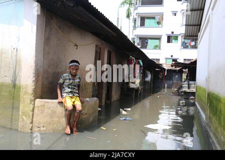 Sylhet, Bangladesch. 24.. Mai 2022. Ein kleiner Junge, der in einer hohen Ecke des Hauses sitzt, versucht, schmutziges Wasser in Sylhet, Bangladesch, zu vermeiden.das Sturzflutwasser dringt in die Häuser der Stadt Sylhet ein, weil der Wasserstand in den Flüssen Surma und Kushiyara steigt. (Bild: © Pinu Rahman/Pacific Press via ZUMA Press Wire) Stockfoto