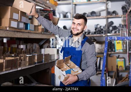 Arbeiter prüft kleine Details für die Sanitäringenieurwesen in der Werkstatt Stockfoto