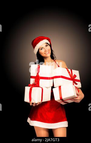 Weihnachtsmütze Weihnachten Frau hält weihnachtsgeschenke lächelnd glücklich und aufgeregt. Nette schöne multi-rassische kaukasische asiatische santa Mädchen auf schwarz isoliert Stockfoto