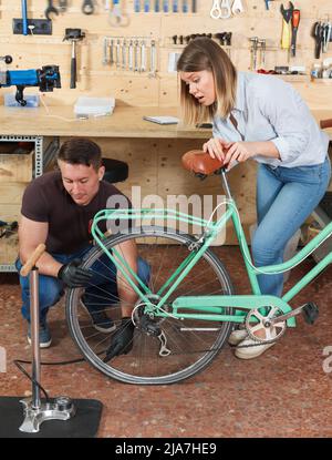 Erwachsene Mann und Frau Pumpen Räder des Fahrrads Stockfoto