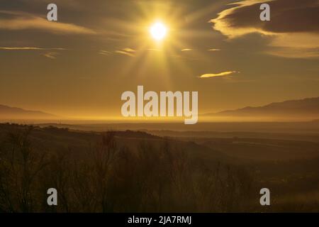 Landschaft aus Feldern und niedrigen Bergen mit Nebel Stockfoto