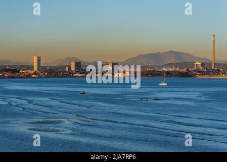 Rinconcillo Strand in Algeciras, mit einer Wolke der Verschmutzung schwimmt über dem Industriegebiet von Los Barrios. Stockfoto