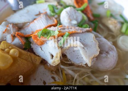 Eiernudelsuppe mit verschiedenen Arten von Fischbällchen und gebratenem Schweinefleisch. Asiatische Nudelsuppe. Stockfoto