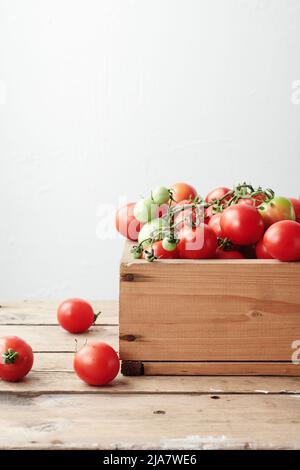 Rote Weintomaten in einer Holzkiste. Kirschtomate. Stockfoto