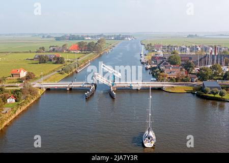 Luftaufnahme von Booten, die darauf warten, durch die Zugbrücke in die Landschaft von Friesland in den Niederlanden zu gehen Stockfoto