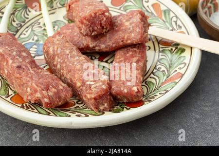 Rohe Mici oder Mititei rumänische traditionelle Gericht, Nahaufnahme auf einer Keramikplatte Stockfoto