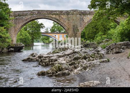 Die berühmte Devil's Bridge und die Hauptbrücke A65 dahinter, die den Fluss Lune in Kirkby Lonsdale, Cumbria, England, Großbritannien, überquert Stockfoto