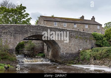 Die malerische Steinbrücke über den Fluss Bain in Bainbridge, Yorkshire Dales, England Stockfoto