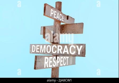 Holzfahrtschild mit den Worten Frieden, Demokratie, Respekt Stockfoto