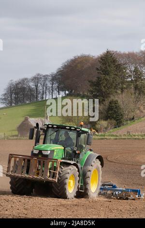 Ein John Deere 6175R Traktor, der einen Scarifier über ein gepflügeltes Feld zieht, um sich auf die Aussaat eines Getreideerdes zu vorbereiten Stockfoto