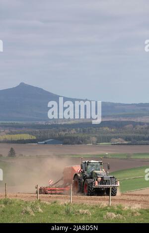 Ein Landwirt, der Gerste auf einer Farm in Aberdeenshire aussaat, in Sichtweite von Bennachie Stockfoto