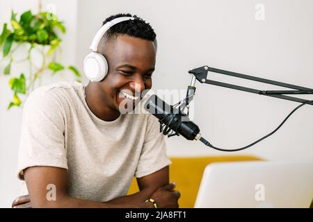 Junger afrikanischer Content-Creator-Mann streamt Live-Podcast aus dem Heimstudio Stockfoto