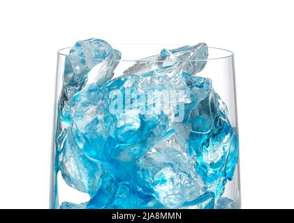 Nahaufnahme von Eiswürfeln und blauem Sirup in Cocktailglas auf weißem Hintergrund Stockfoto