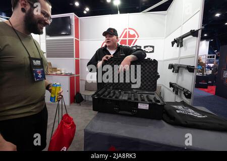 Houston, Texas, USA. 28.. Mai 2022. Ein Pistolenenthusiast schaut am Samstagmorgen auf der Messe der National Rifle Association (NRA) auf Unterdrücker von Nemo. Die Ausstellungsstücke erstrecken sich über fast 14 Hektar im George R. Brown Convention Center. (Bild: © Bob Daemmrich/ZUMA Press Wire) Stockfoto