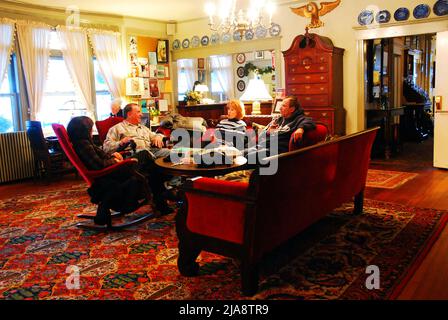 Freunde genießen eine entspannende Unterhaltung in der Lobby des Red Lion Inn in Stockbridge, Massachusetts Stockfoto