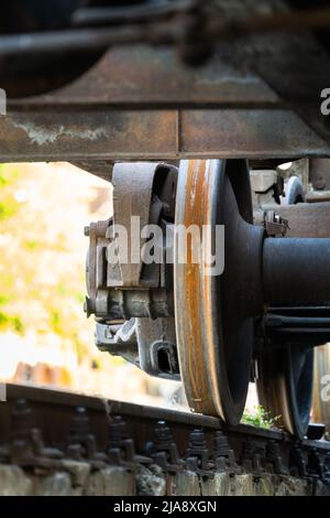Nahaufnahme der alten rostigen Räder des Zuges. Eisenbahnwaggons auf Schiene. Stockfoto