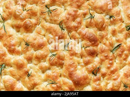 Nahaufnahme mit hausgemachtem Focaccia-Brot, Blick von oben. Vollformat-Hintergrund mit köstlichem Rosmarin-Focaccia, gebacken mit Sauerteig. Stockfoto