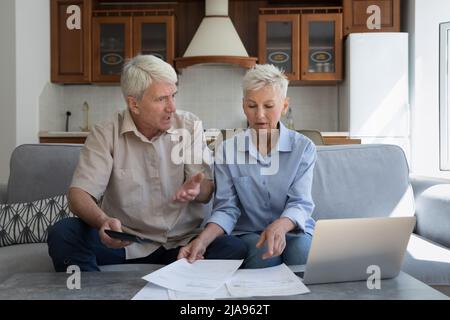 Gestresste Großeltern haben Papierkram finden Mangel an Geld auf Rechnung Stockfoto