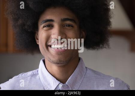 Fröhlich fröhlich afrikanischen jungen Mann Indoor Kopf geschossen Porträt Stockfoto