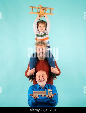 Vatertag. Kind hat Spaß mit Spielzeug Flugzeug. Männer Generation Familie mit drei verschiedenen Generationen Alter Großvater Vater und Sohn. Familienabenteuer Stockfoto