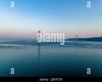 Luftaufnahme des Sonnenuntergangs am Horizont hinter der Akashi Kaikyo, der längsten Hängebrücke der Welt Stockfoto