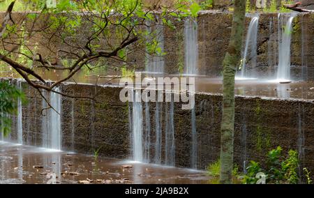 Der Gold Creek Dam fließt durch eine kleine Wassermenge, die über die abgestufte Wand fließt Stockfoto