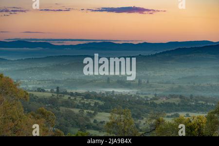 Bevor die Morgenröte über den Toowoomba Ranges, Queensland. Das frühe Licht strahlt ein ruhiges Leuchten aus und malte die Landschaft in sanften, vor Sonnenaufgang anmutenden Tönen Stockfoto