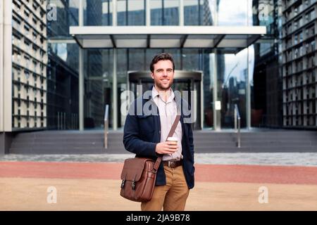 Lächelnder Geschäftsmann vor dem Bürogebäude Stockfoto