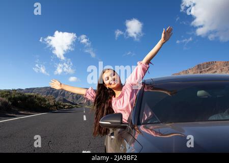 Junge glückliche schöne Frau geht auf Sommerreise Reise im Auto. Stockfoto