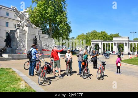 Reiseleiter zeigt geführte Tour für eine Gruppe von Frauen und Männern mit gemieteten Fahrrädern bei einer Besichtigungstour zum Hyde Park Corner London England UK Stockfoto