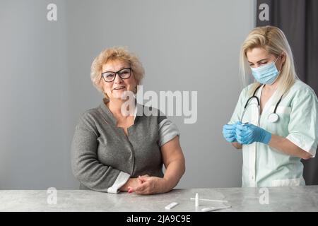 Seniorenimpfungskonzept. Ältere Menschen erhalten im Krankenhaus von der Krankenschwester eine Immunimpfung am Arm wegen Grippeimpfung, Lungenentzündung und Gürtelrose. Arzt gibt ein Stockfoto