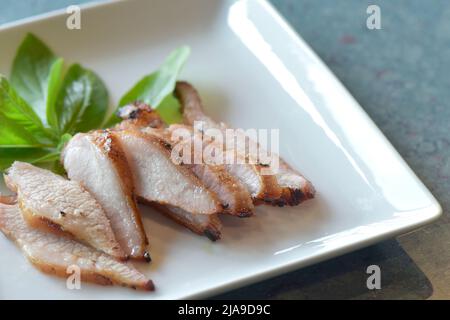 Gegrillter Schweinefleisch-Hals, Thai-Küche. Nahaufnahme Charcoal-Boiled Schweinefleisch-Hals auf einem Teller Weiß ist ein beliebter Vorspeise in Thailand. Ausgewählter Fokus Stockfoto