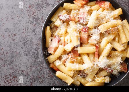 Pasta alla Gricia Teller mit köstlichen italienischen Pasta mit Guanciale und Pecorino, typisch italienische und römische Speisen in der Nähe auf dem Teller auf dem Tisch. Hori Stockfoto