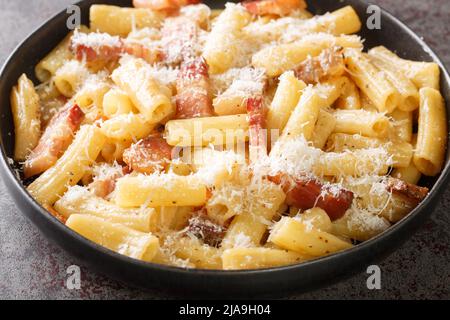 Pasta alla Gricia Teller mit köstlichen italienischen Pasta mit Guanciale und Pecorino, typisch italienische und römische Speisen in der Nähe auf dem Teller auf dem Tisch. Hori Stockfoto